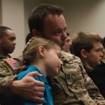 service member holding child