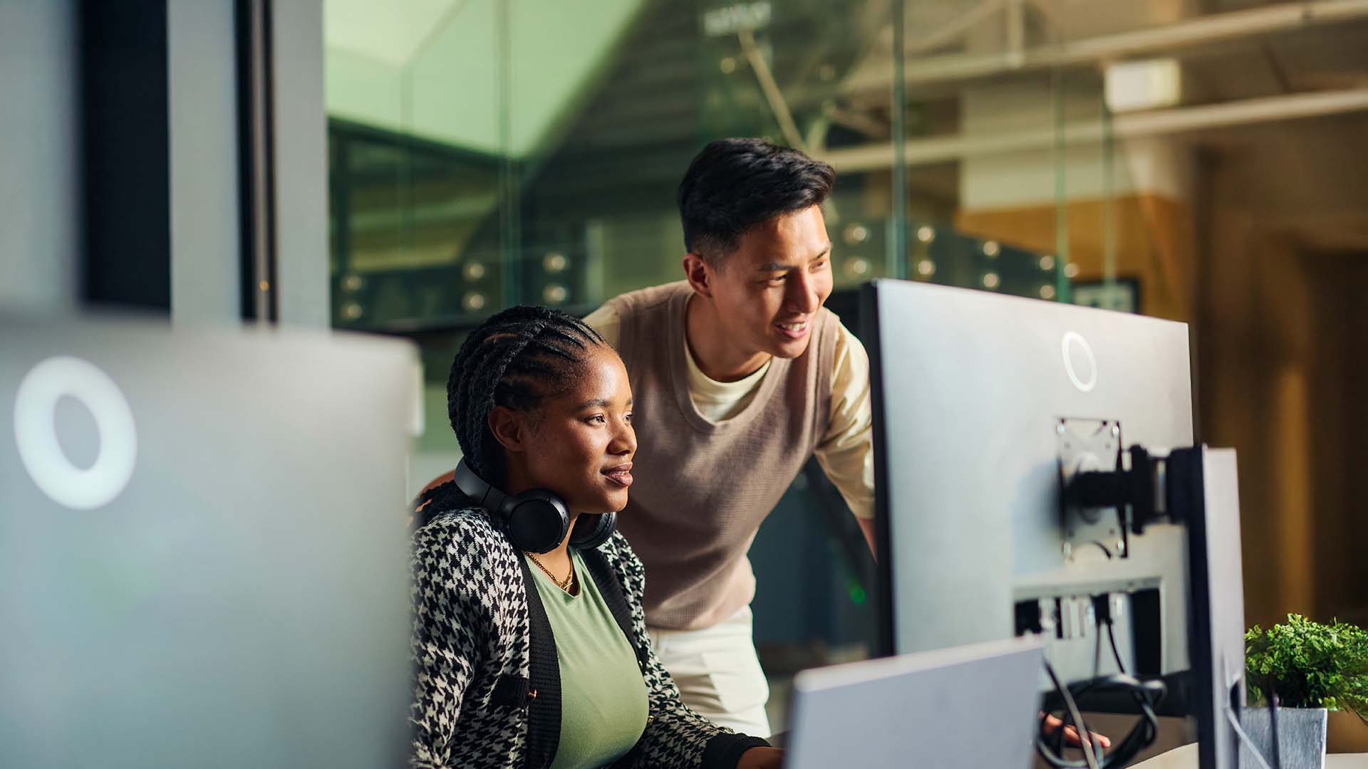 Coworkers collaborating at computer screens