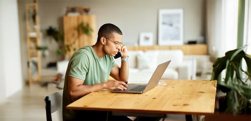 man on phone using laptop
