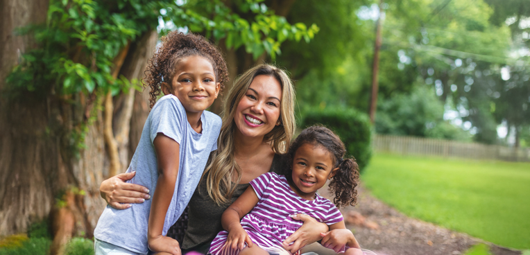 Mother holding two daughters