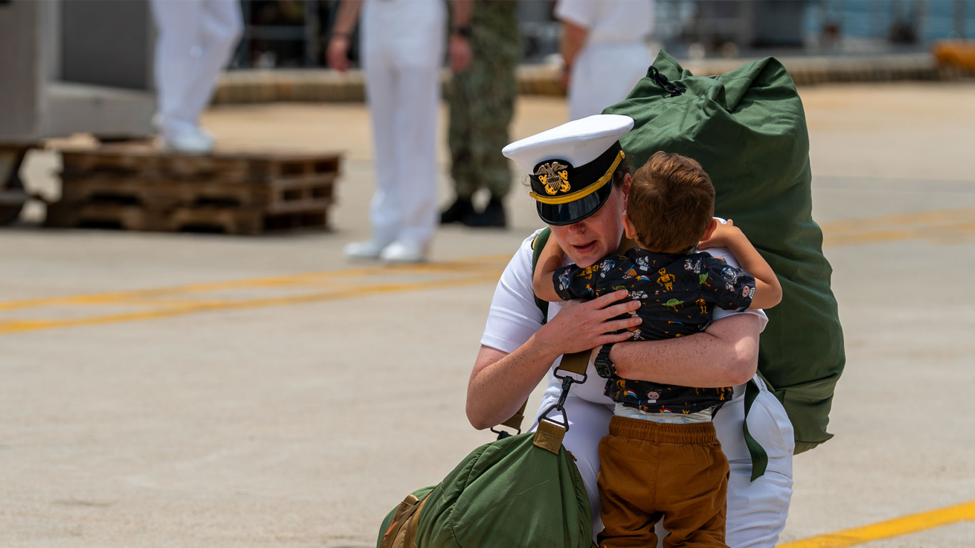 Service member embracing child