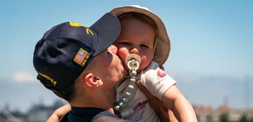 Service member kissing child