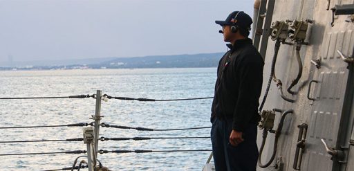 Service member looks out over water