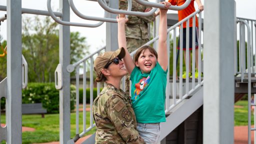 Service member mother playing with child at playground