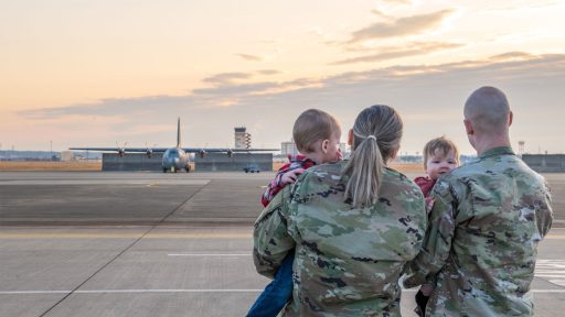 Service members holding children