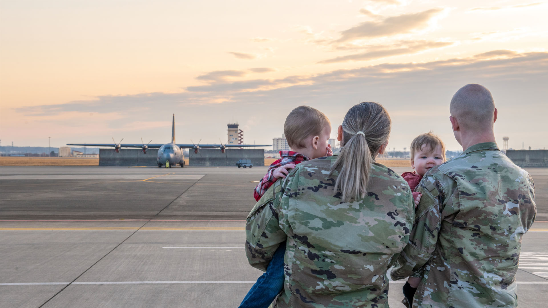 Service members holding children