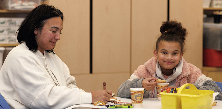 child colors with parent at table