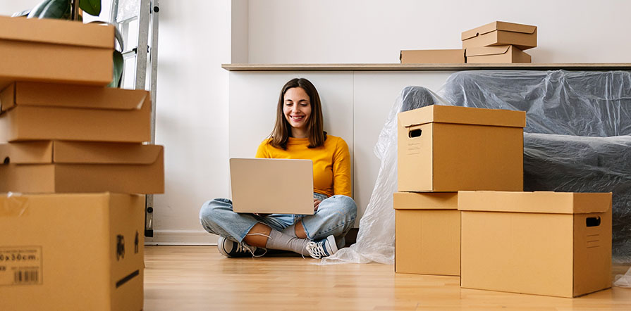 woman on computer surrounded by boxes