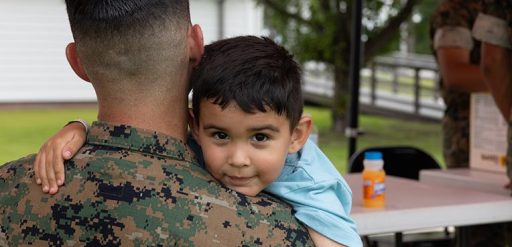 service member holding child