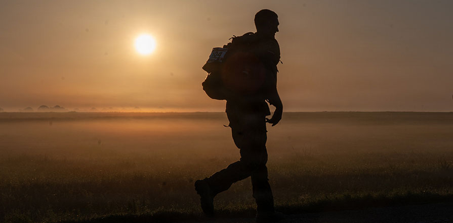 service member walking with pack