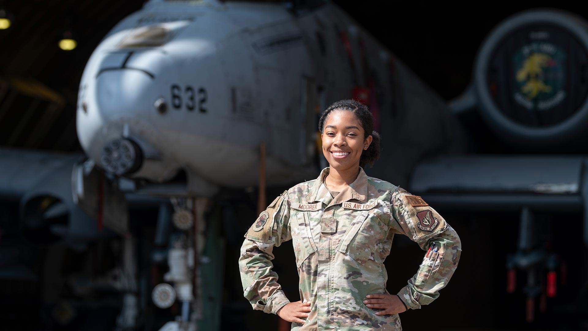 woman stands in front of plane