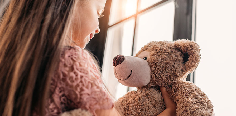 girl holding stuffed animal