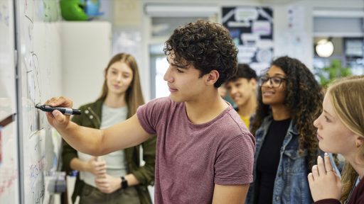 Teen writing on whiteboard