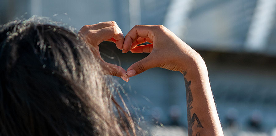 woman holding hands in heart shape