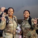 Service members posing, showing peace signs