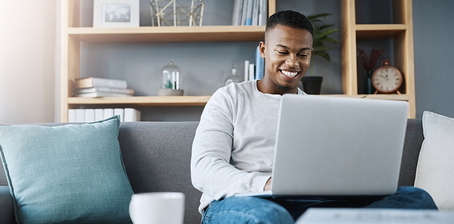 man sitting on couch with laptop
