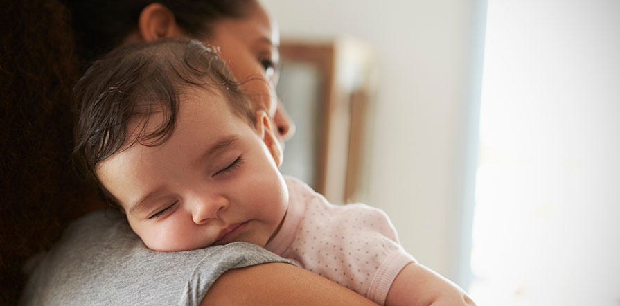 mother holding sleeping baby