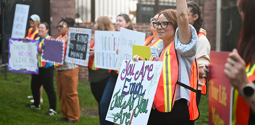 people holding signs with messages of hope