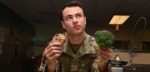 service member holding cookie and broccoli