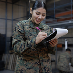 Service member writing on notepad