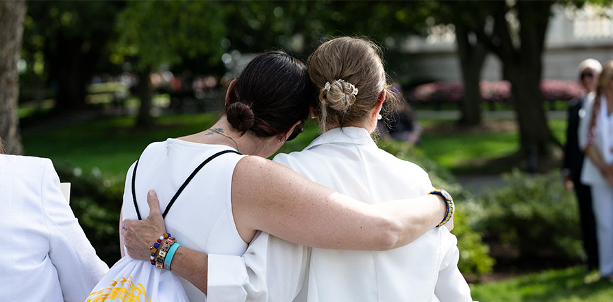two gold star members comforting each other