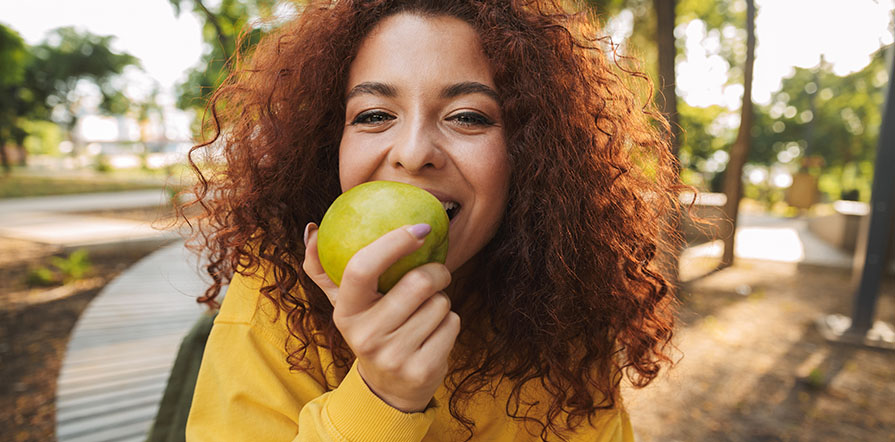 woman about to bite into apple