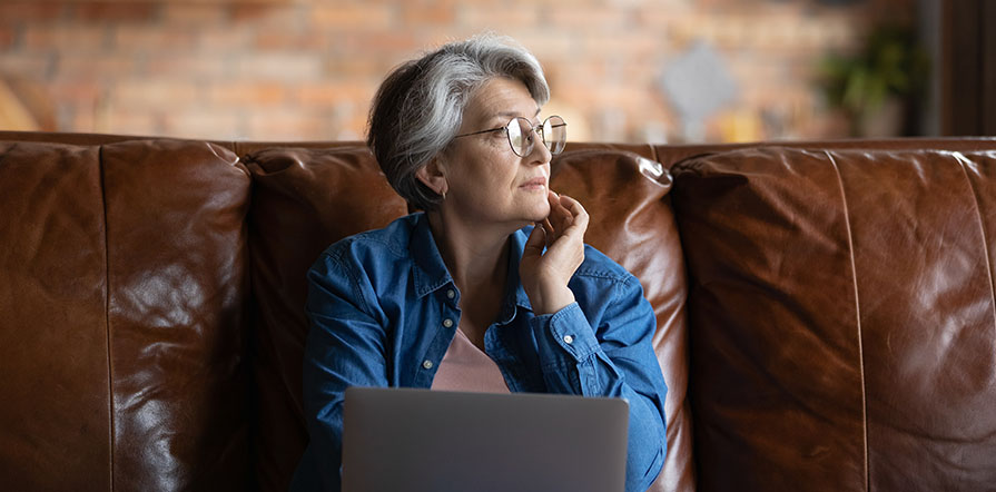 woman sitting on couch with laptop