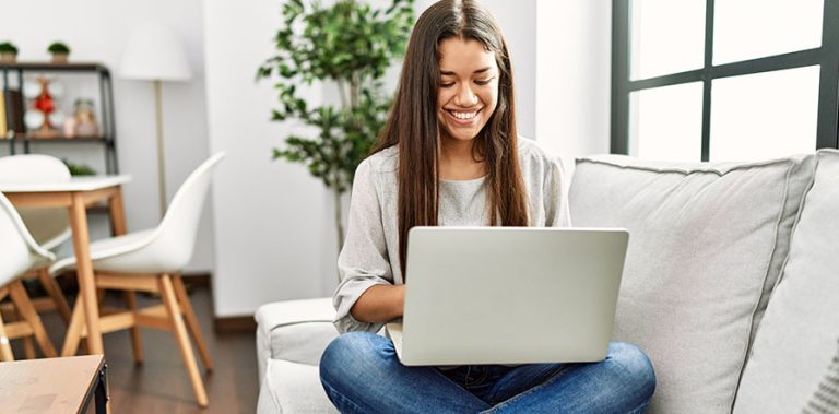 woman sitting on couch with laptop