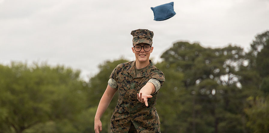 service member plays cornhole