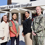 service member and Red Cross hospital staff pose